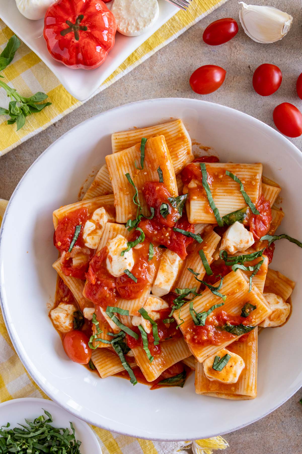 Pasta alla sorrentina made with paccheri pasta, cherry tomatoes and mozzarella topped with basil chiffonade.