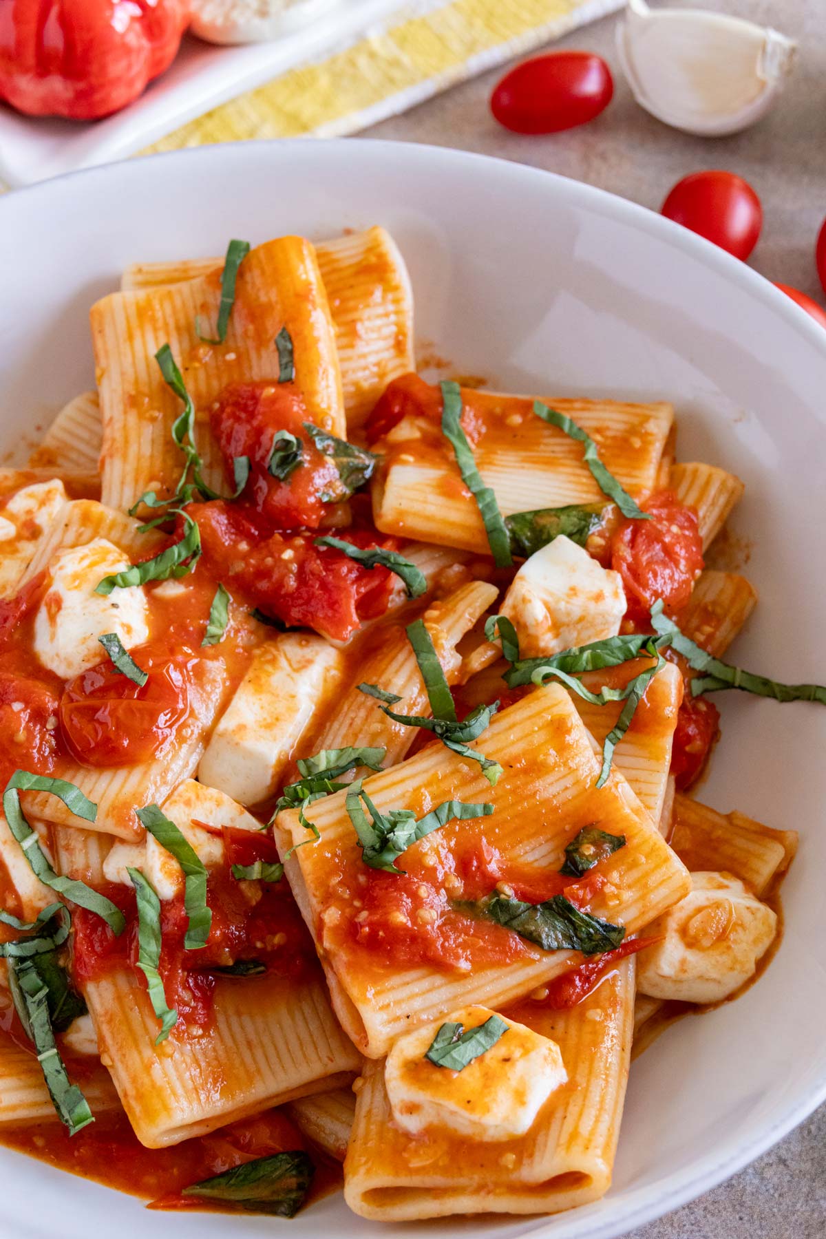 Paccheri pasta with a sauce of cooked cherry tomatoes, fresh basil, and fresh mozzarella cheese.