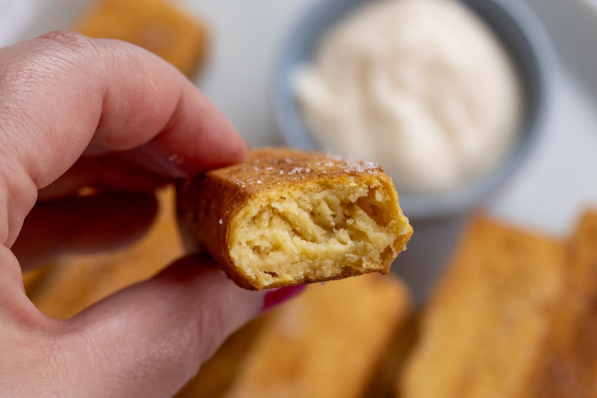 Cross-section of a panisse with a bite take out, showing off the creamy interior.
