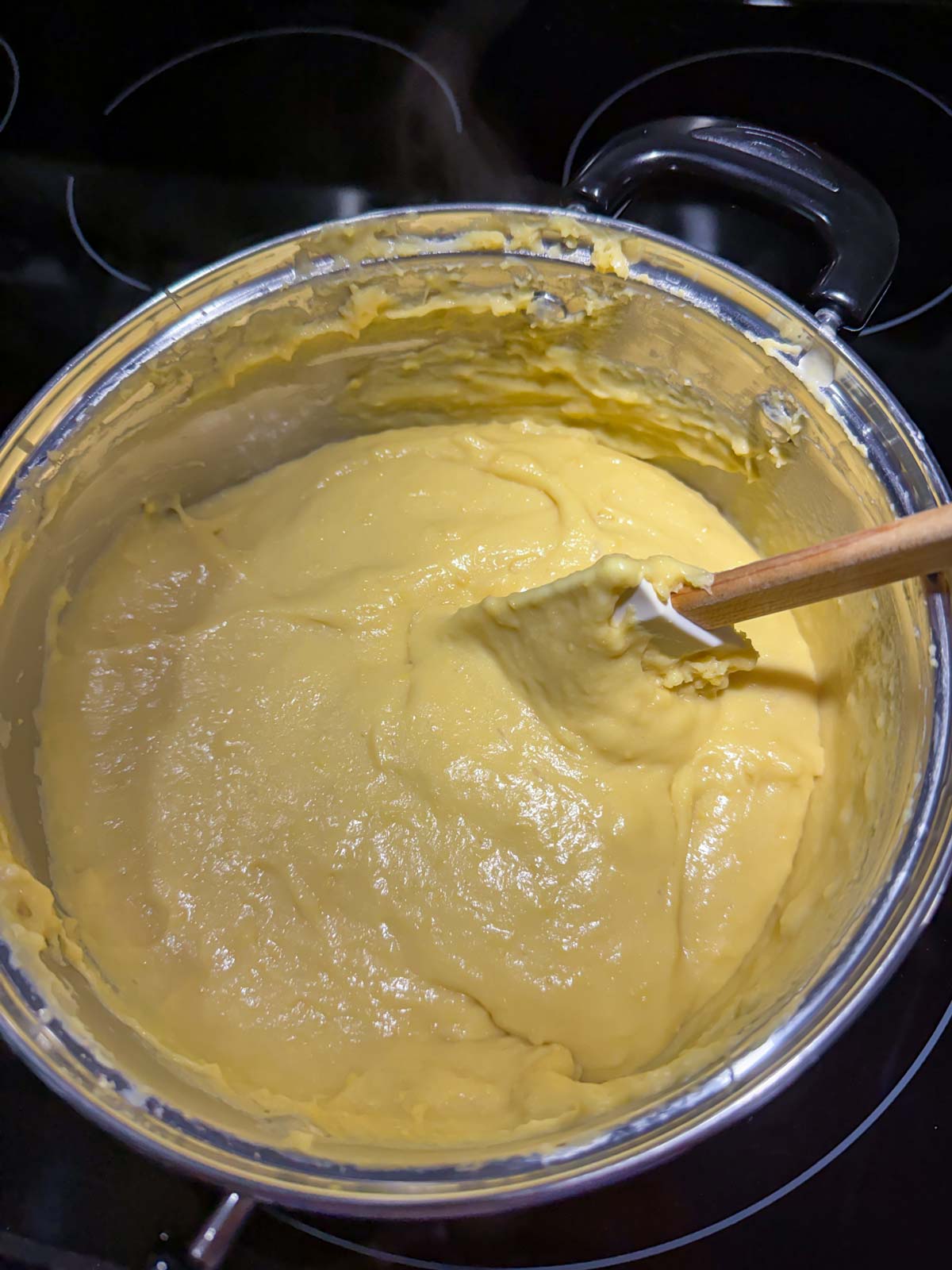 Stirring a mixture of chickpea flour and simmering water on the stovetop until very thick.