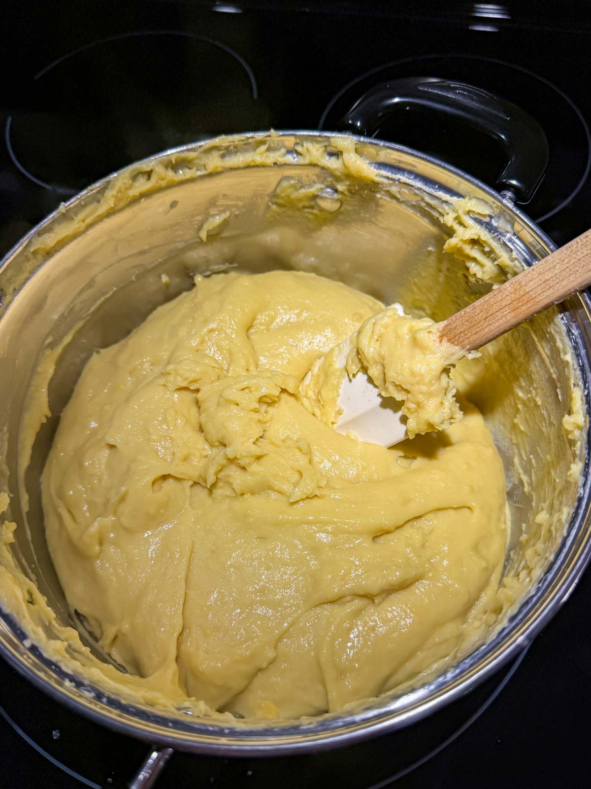 A thick mixture of chickpea flour combined with water pulling away from the sides of the pan.
