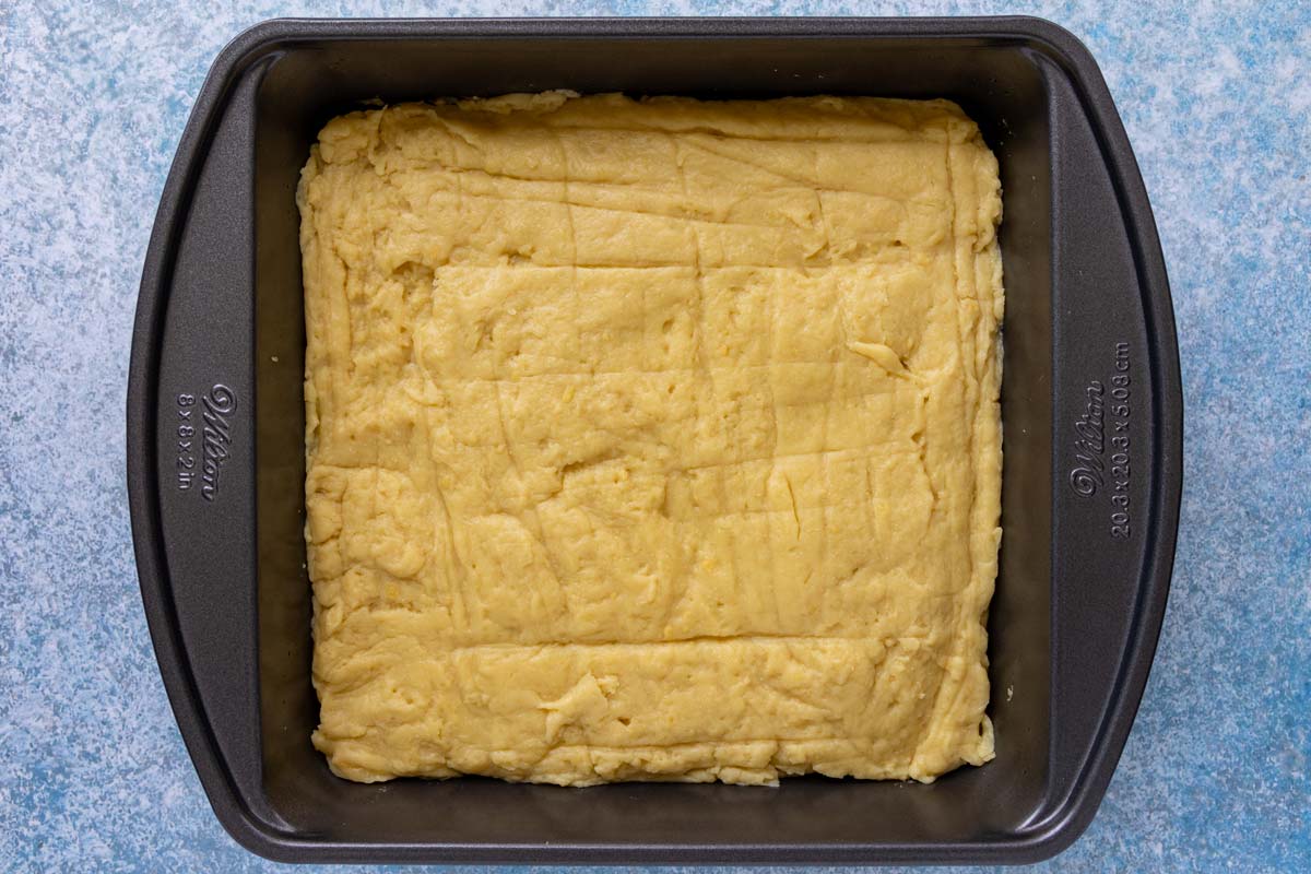 A thick mixture spread out into a square baking dish.