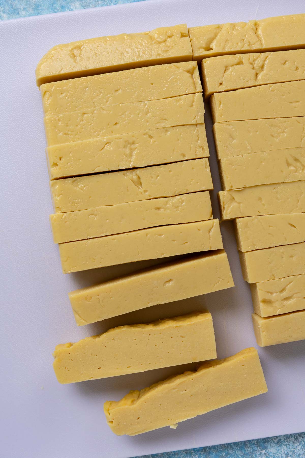A firm panisse mixture cut into rectangular batons on a cutting board.