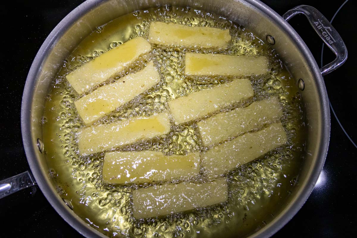 Pan-frying panisses in olive oil.