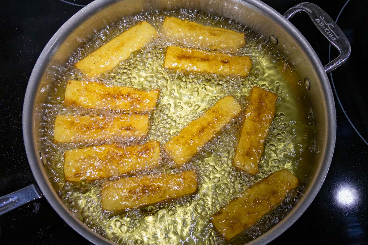 Panisses shallow-frying in olive oil after flipping over halfway through.