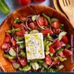 Authentic Greek salad in a woven wood salad bowl.