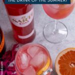 A couple glasses of Sarti Spritz next to a bottle of Sarti Rosa and half a grapefruit.