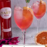 A refreshing glass of Sarti Spritz garnished with a slice of grapefruit and a butterfly toothpick.