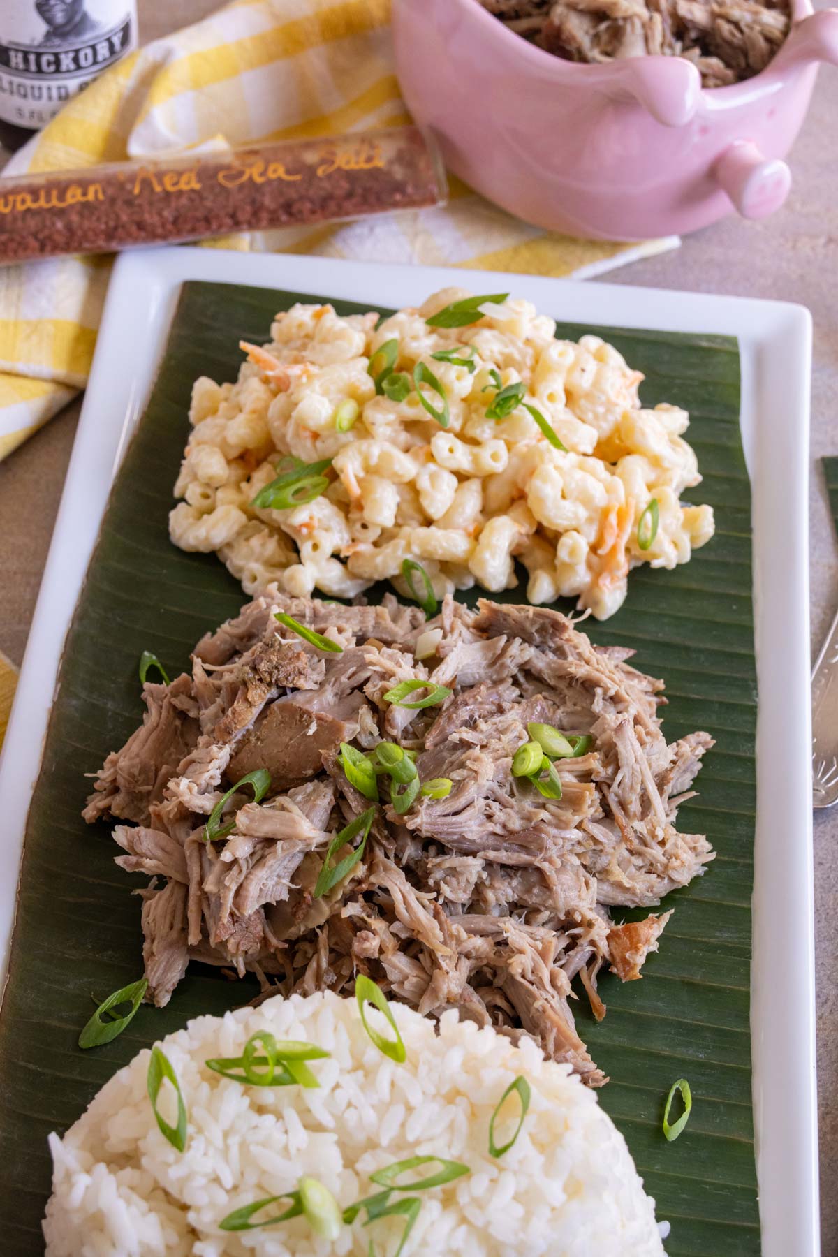 Shredded slow cooker kalua pork topped served with plain white rice and Hawaiian mac salad.