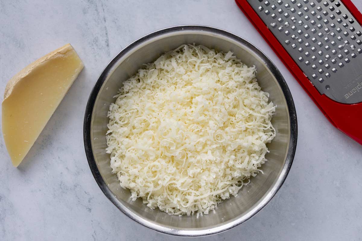 Freshly grated provolone del monaco cheese in a small bowl.